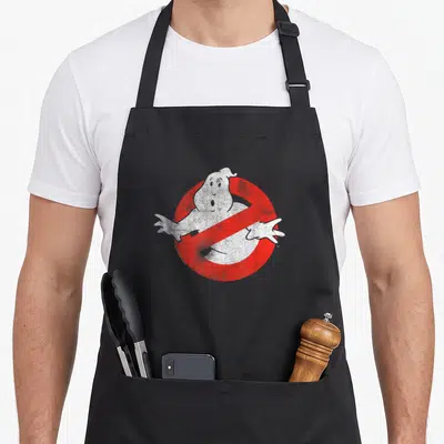 Distressed ghost apron - White ghost figure overlapping red prohibition circle with diagonal slash in distressed style — shown on a black cotton canvas apron against a white background
