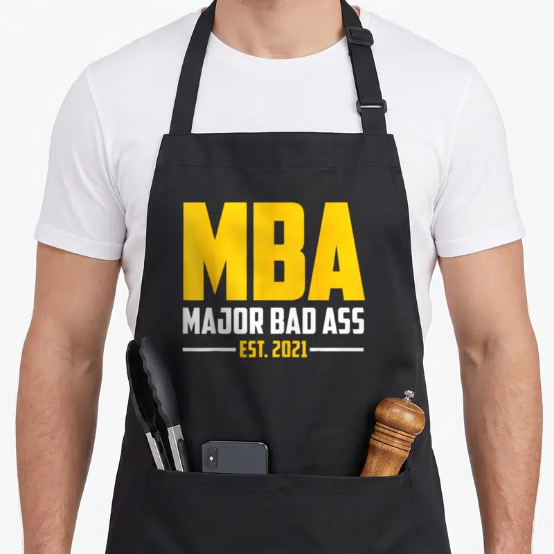 Graduation degree master apron - Yellow and white text reading MBA Major Bad Ass Est 2021 on black fabric — shown on a black cotton canvas apron against a white background
