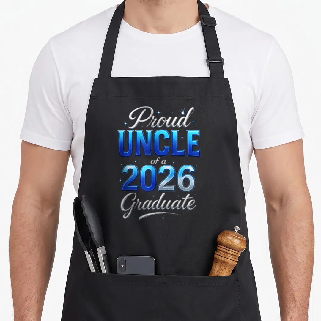 Uncle diploma apron - Stacked blue and white Proud UNCLE of a 2026 Graduate text with small stars — shown on a black cotton canvas apron against a white background