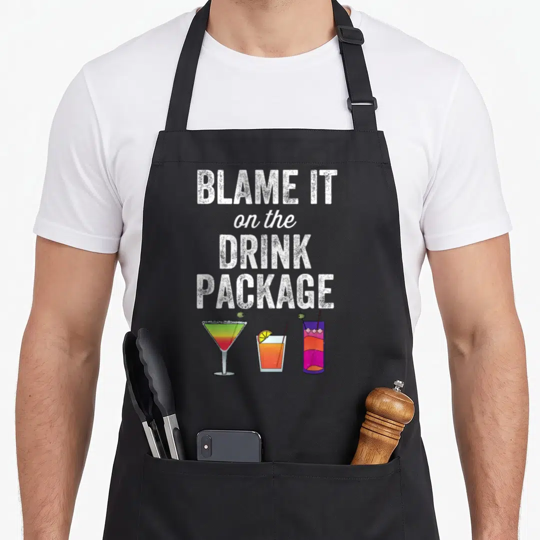 Blame cruiser apron - Blame It on the Drink Package text above three cocktails in white, orange, purple, and green — shown on a black cotton canvas apron against a white background