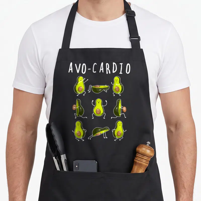 Cardio fruit apron - AVO-CARDIO text above nine cartoon avocados doing exercises in green and brown — shown on a black cotton canvas apron against a white background