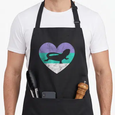 Cute bearded dragon apron - Grey lizard silhouette inside a heart with purple, teal, and white horizontal stripes — shown on a black cotton canvas apron against a white background