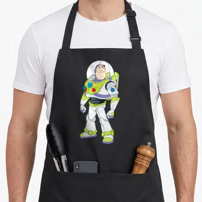 Pose strong apron - Full body cartoon Buzz Lightyear standing in white lime green and purple space suit — shown on a black cotton canvas apron against a white background