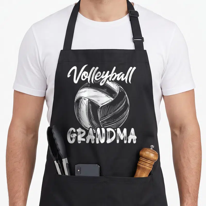 Volleyball family grandma apron - White line art volleyball centered between script Volleyball text and block GRANDMA — shown on a black cotton canvas apron against a white background