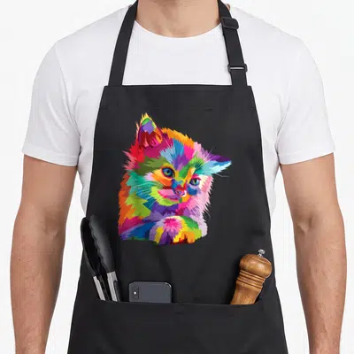 Kitten colorful aprons - Multicolored geometric cat portrait in blue red yellow green purple mosaic style — shown on a black cotton canvas apron against a white background