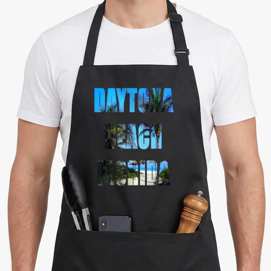 Daytona beach florida apron - Stacked text DAYTONA BEACH FLORIDA filled with beach photo and palm trees — shown on a black cotton canvas apron against a white background