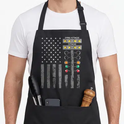 Strip american flag apron - Distressed US flag background with vertical drag racing lights and pre-stage stage text — shown on a black cotton canvas apron against a white background
