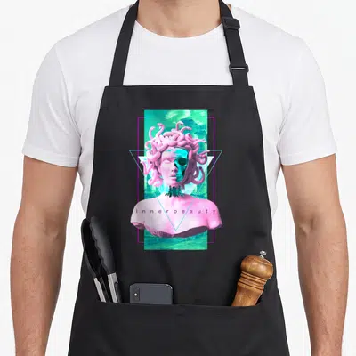 Vaporwave skull apron - Pink Medusa bust with teal skull face, blue triangle, pink rectangle, and inner beauty text — shown on a black cotton canvas apron against a white background