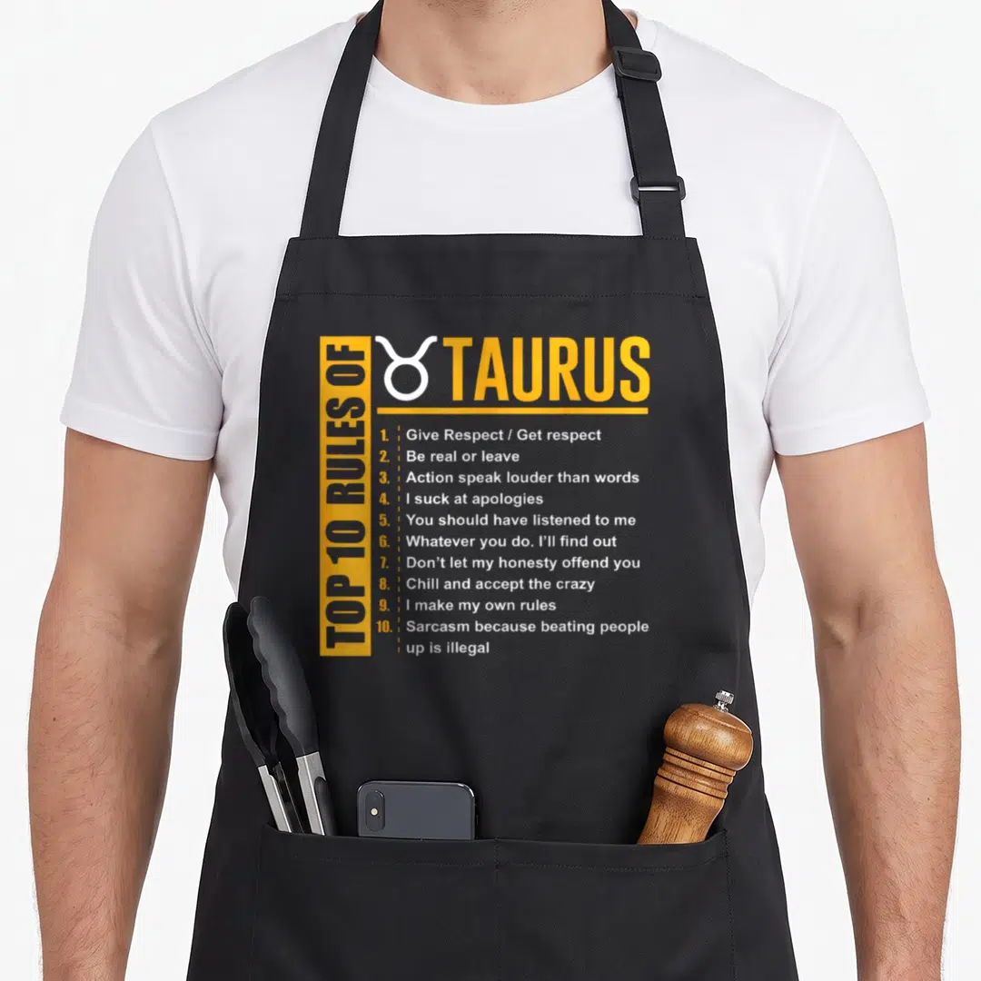Birthday taurus aprons - Yellow and white Top 10 Rules of Taurus typography with zodiac symbol — shown on a black cotton canvas apron against a white background