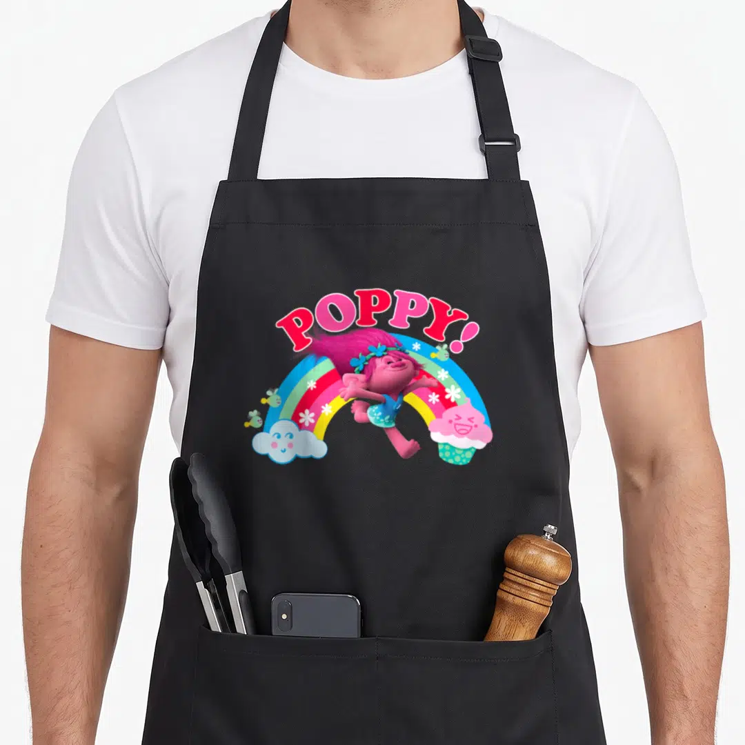 Cute poppy troll apron - POPPY! text over a girl jumping in front of a rainbow with a cloud and cupcake — shown on a black cotton canvas apron against a white background