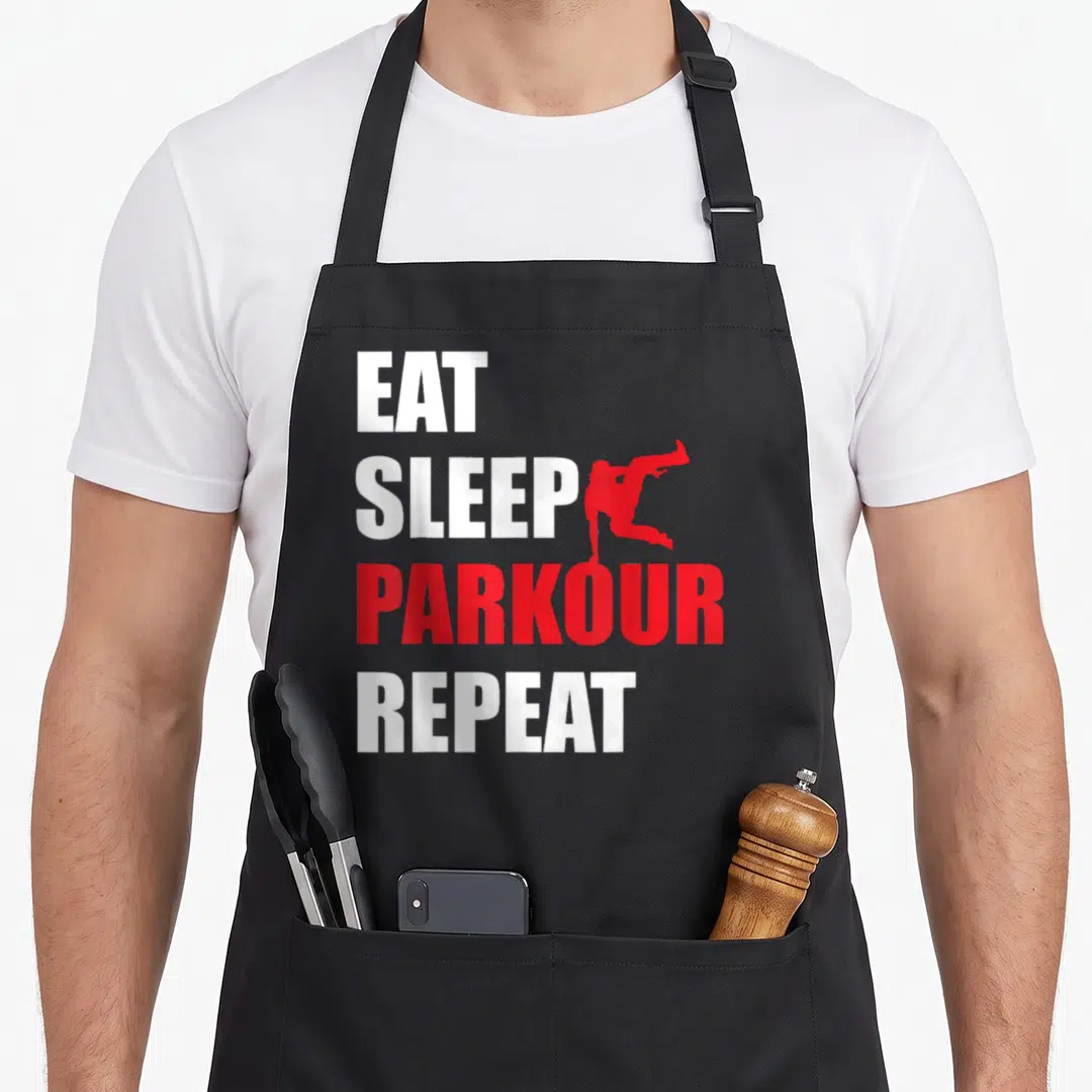 Parkour shoe apron - EAT SLEEP PARKOUR REPEAT text with red jumping figure silhouette — shown on a black cotton canvas apron against a white background