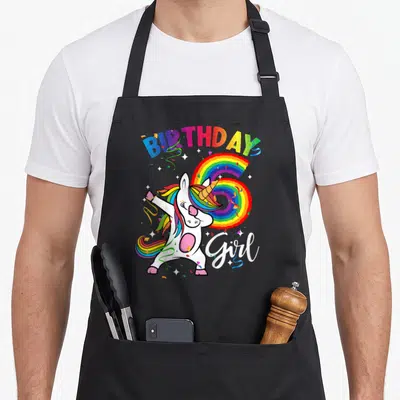 Gif birthday apron - Cartoon unicorn dabbing over rainbow number 6 with BIRTHDAY Girl text — shown on a black cotton canvas apron against a white background