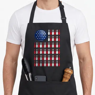 Bowling american flag apron - Blue star bowling ball and red white pin flag pattern — shown on a black cotton canvas apron against a white background