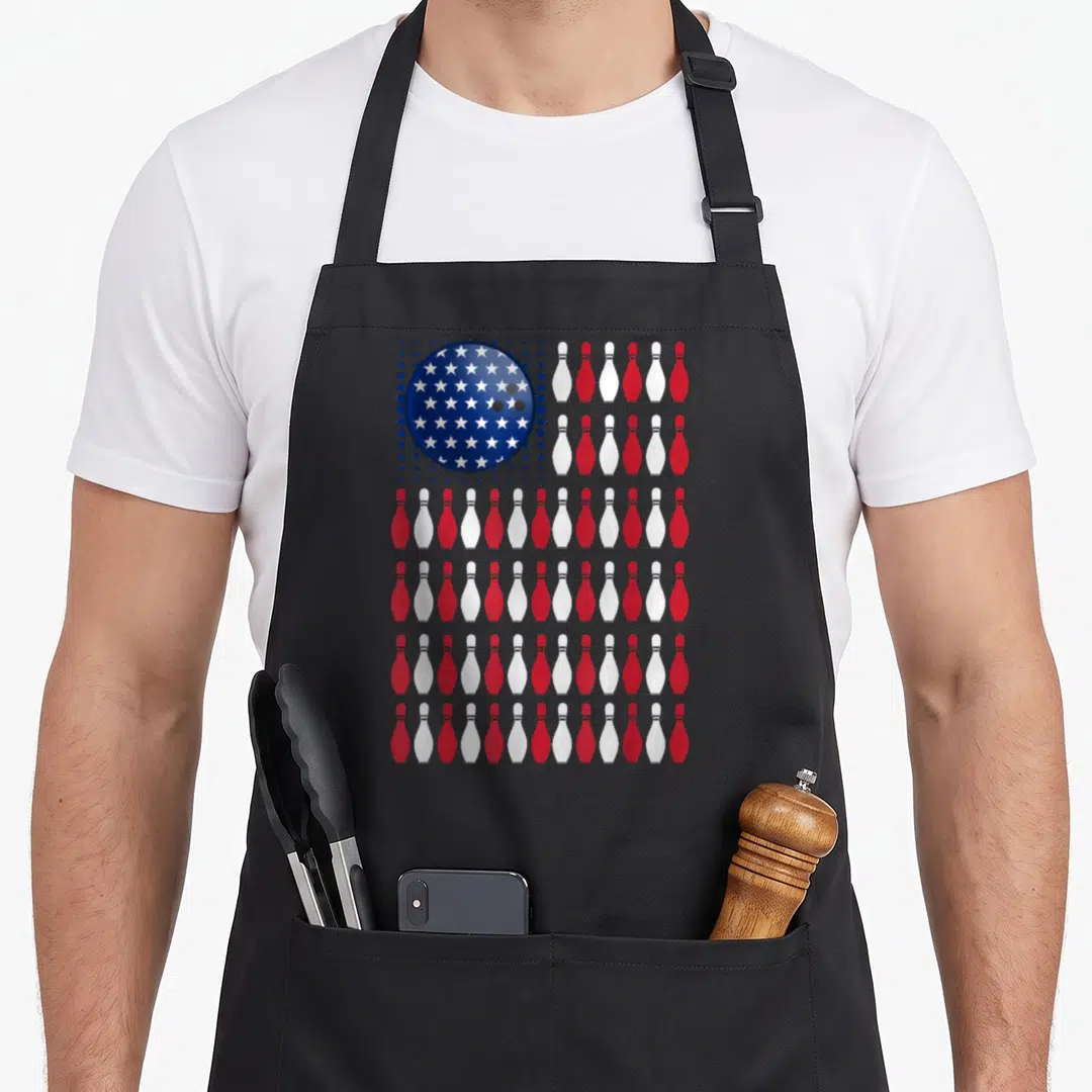 Bowling american flag apron - Blue star bowling ball and red white pin flag pattern — shown on a black cotton canvas apron against a white background