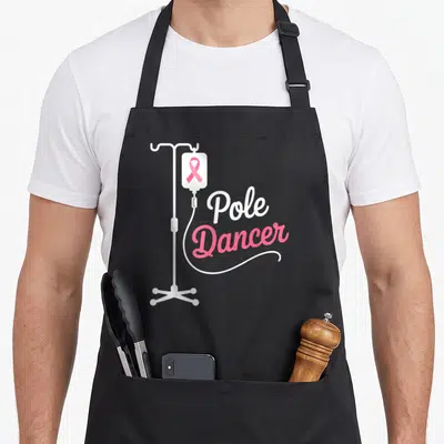 Pole chemo warrior apron - White IV pole with pink ribbon and curved tube under Pole Dancer text — shown on a black cotton canvas apron against a white background