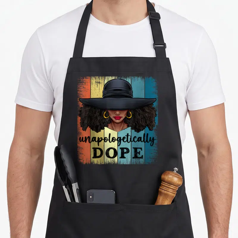 Dope african american aprons - Cartoon woman wide brim hat gold hoops red lips unapologetically DOPE striped background — shown on a black cotton canvas apron against a white background