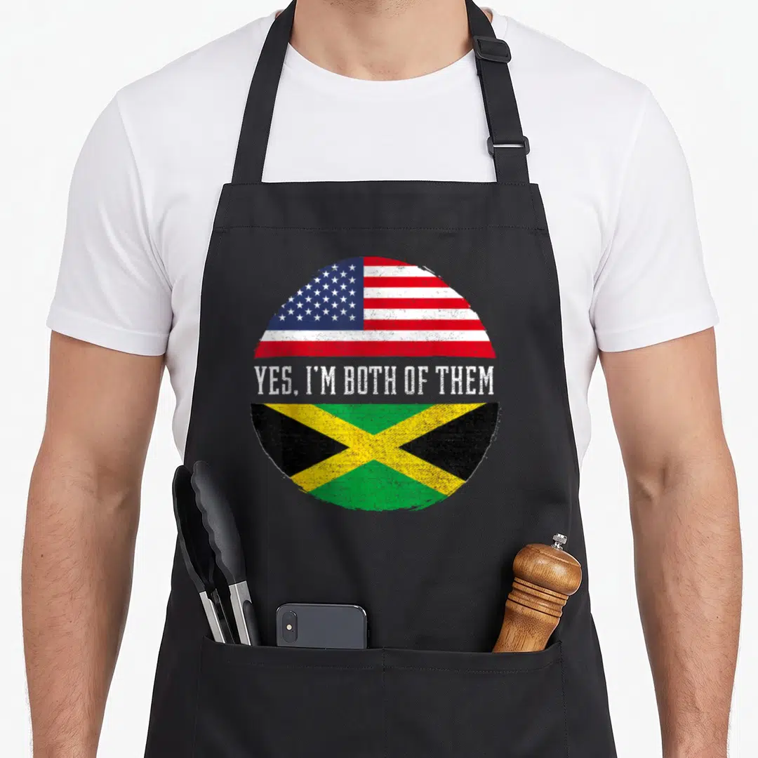 Heritage american flag apron - Distressed circular split US and Jamaica flag with Yes Im Both Of Them text — shown on a black cotton canvas apron against a white background