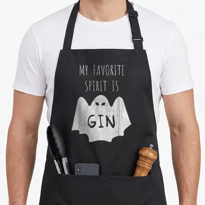 Food i love gin apron - White cartoon ghost with GIN on chest under My Favorite Spirit Is Gin text — shown on a black cotton canvas apron against a white background