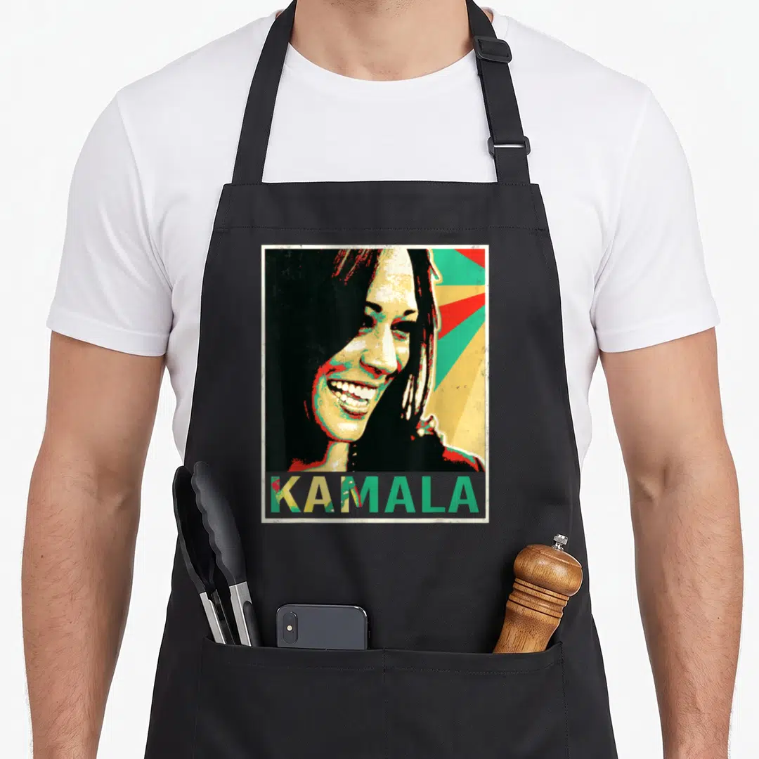 Madam high chair apron - Retro Kamala Harris portrait with KAMALA text and colorful sunburst rays — shown on a black cotton canvas apron against a white background