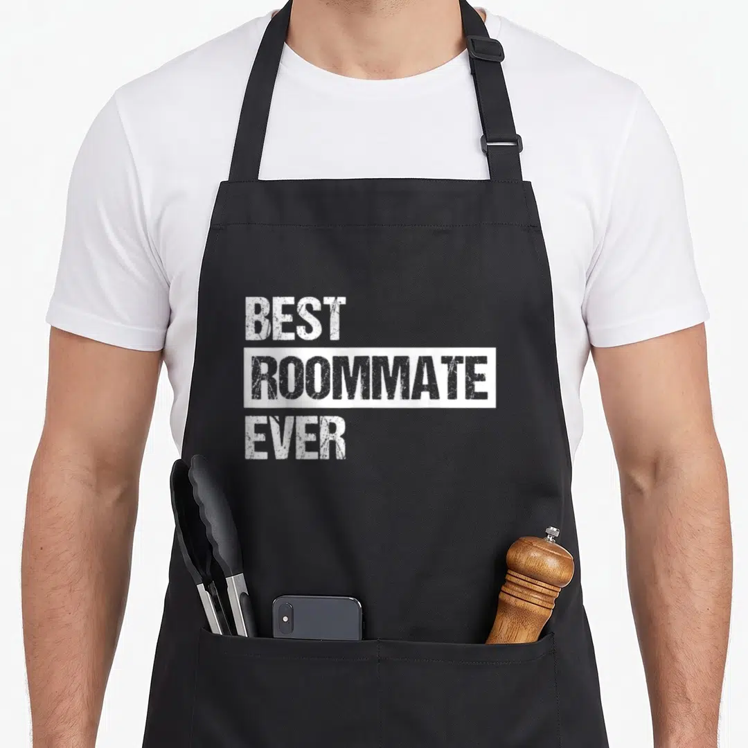 Retro roommate apron - White distressed text reading best roommate ever stacked on black background — shown on a black cotton canvas apron against a white background