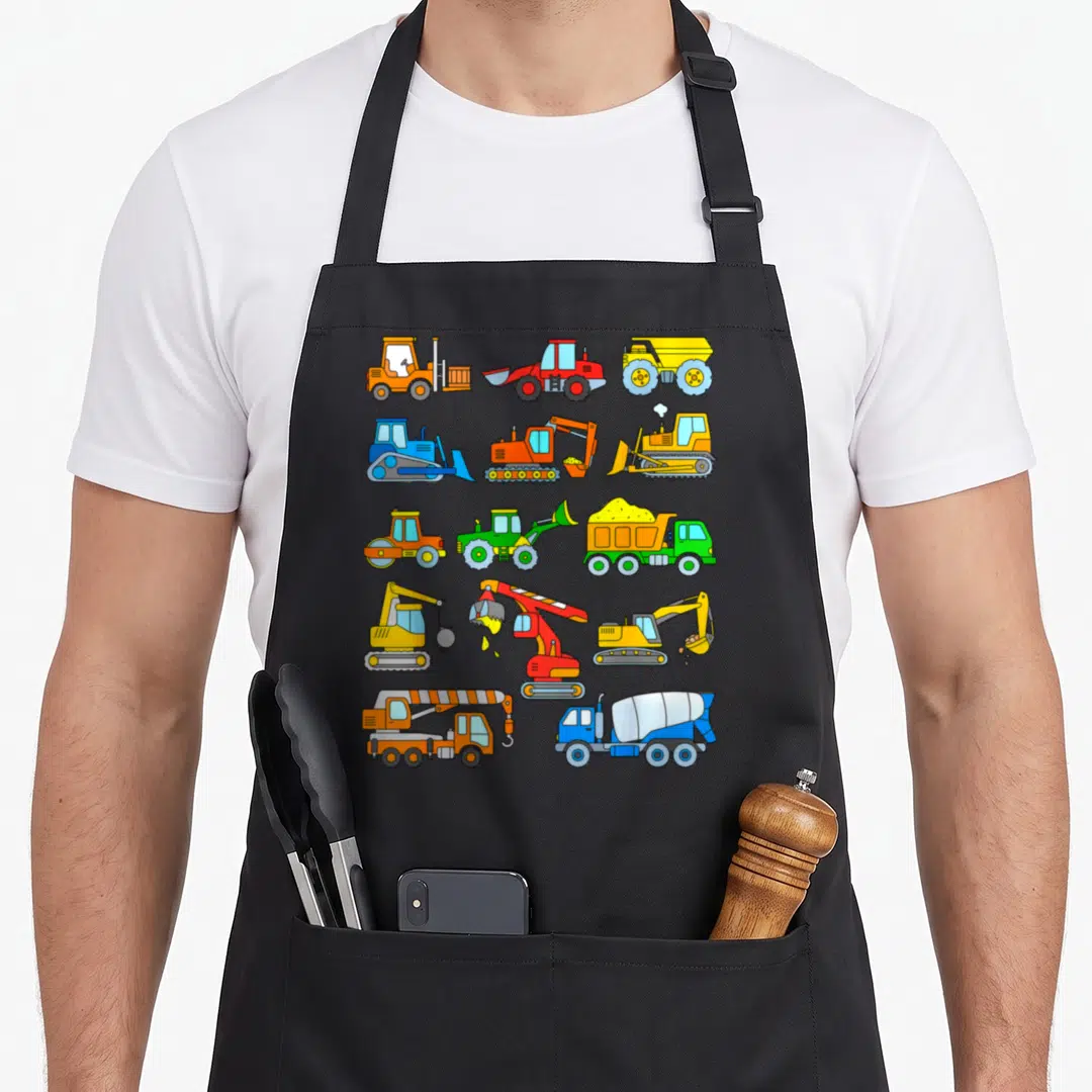 Excavator construction apron - Grid of 13 cartoon construction vehicles in yellow orange blue red and green — shown on a black cotton canvas apron against a white background