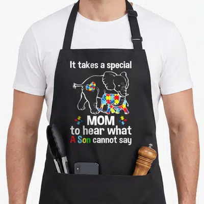 Special mom and son aprons - Elephant autism awareness apron with puzzle pattern and text about hearing what a son — shown on a black cotton canvas apron against a white background