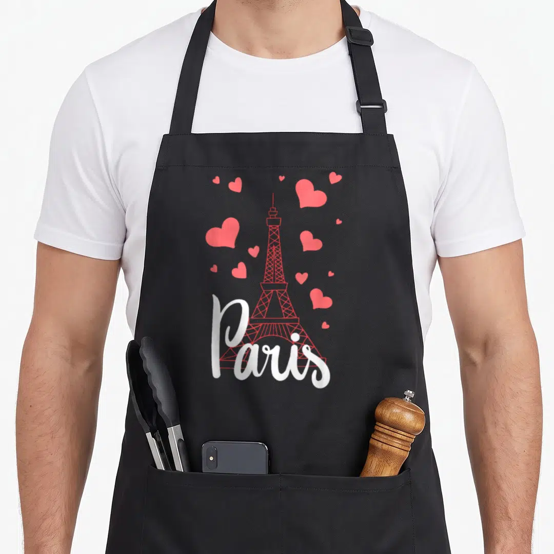 France eiffel tower paris apron - Red Eiffel Tower outline with scattered hearts and white Paris script on black fabric — shown on a black cotton canvas apron against a white background