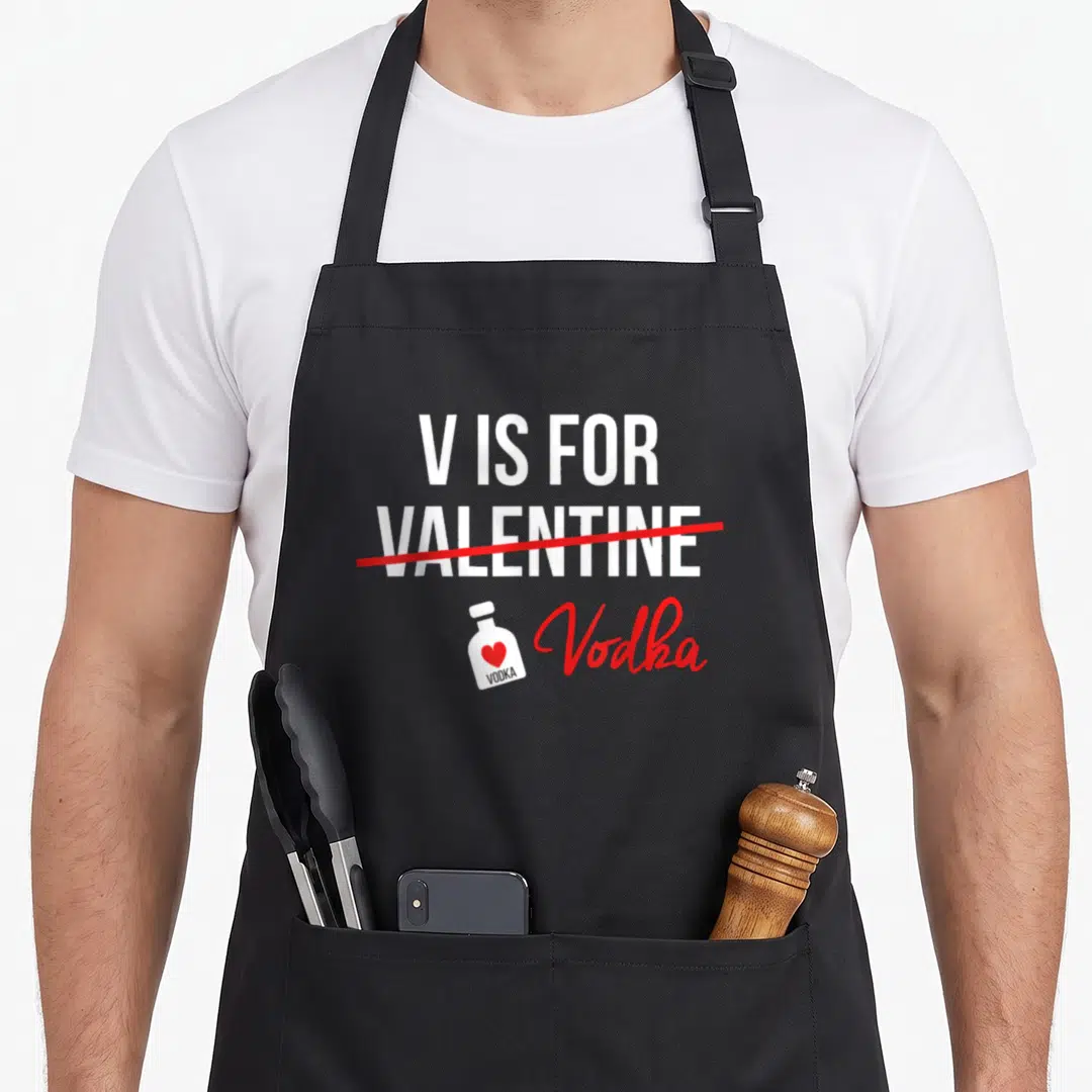 Boyfriend valentine's day apron - V IS FOR VALENTINE crossed out with vodka bottle icon and red script text — shown on a black cotton canvas apron against a white background