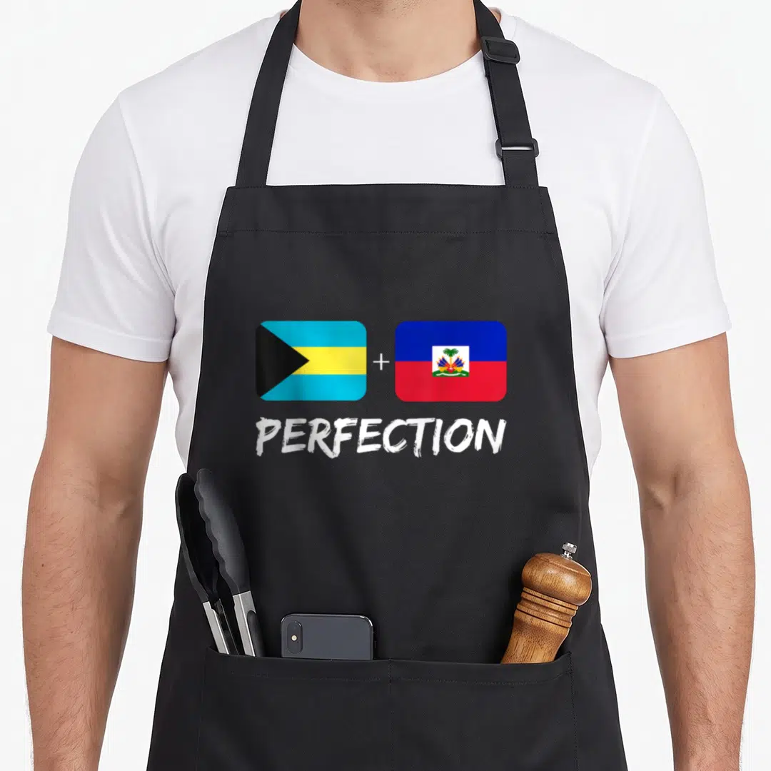 Bahamian heritage aprons - Two flags with plus sign and white PERFECTION text below — shown on a black cotton canvas apron against a white background