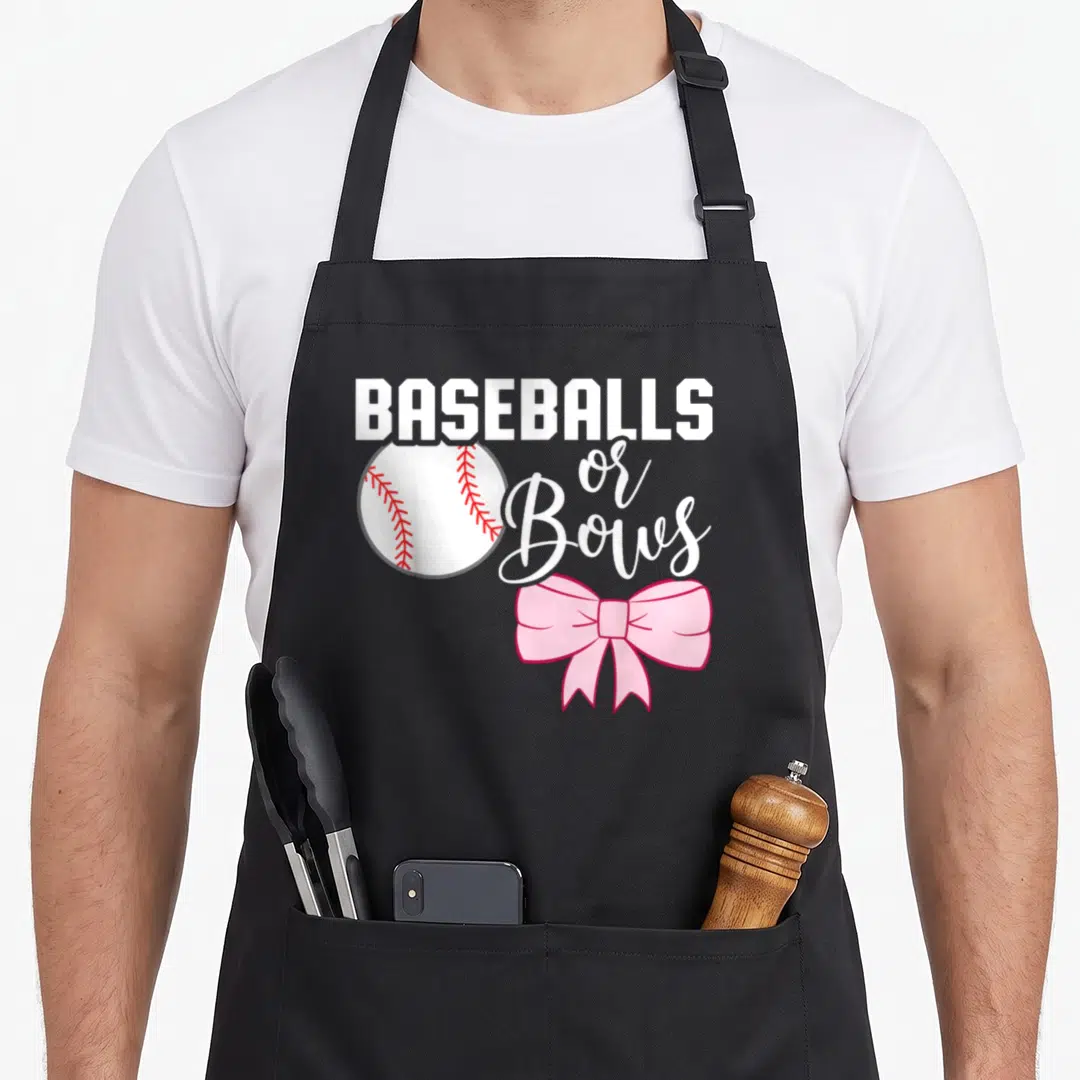 Baseball bow apron - BASEBALLS or Bows text with cartoon baseball and pink bow illustration — shown on a black cotton canvas apron against a white background