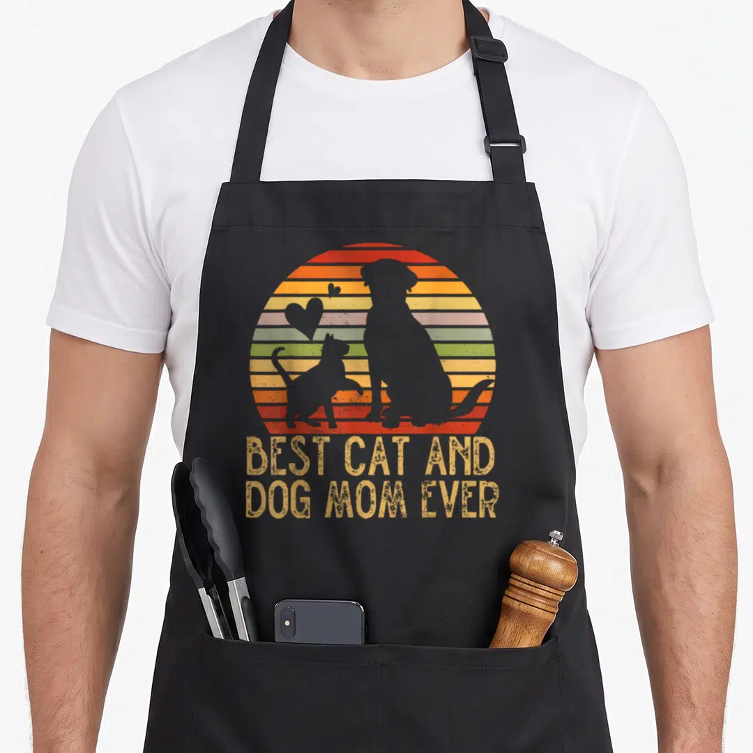 Furmama mother's day aprons - Retro sunset silhouettes of a dog and cat with stacked text best cat and dog mom ever — shown on a black cotton canvas apron against a white background