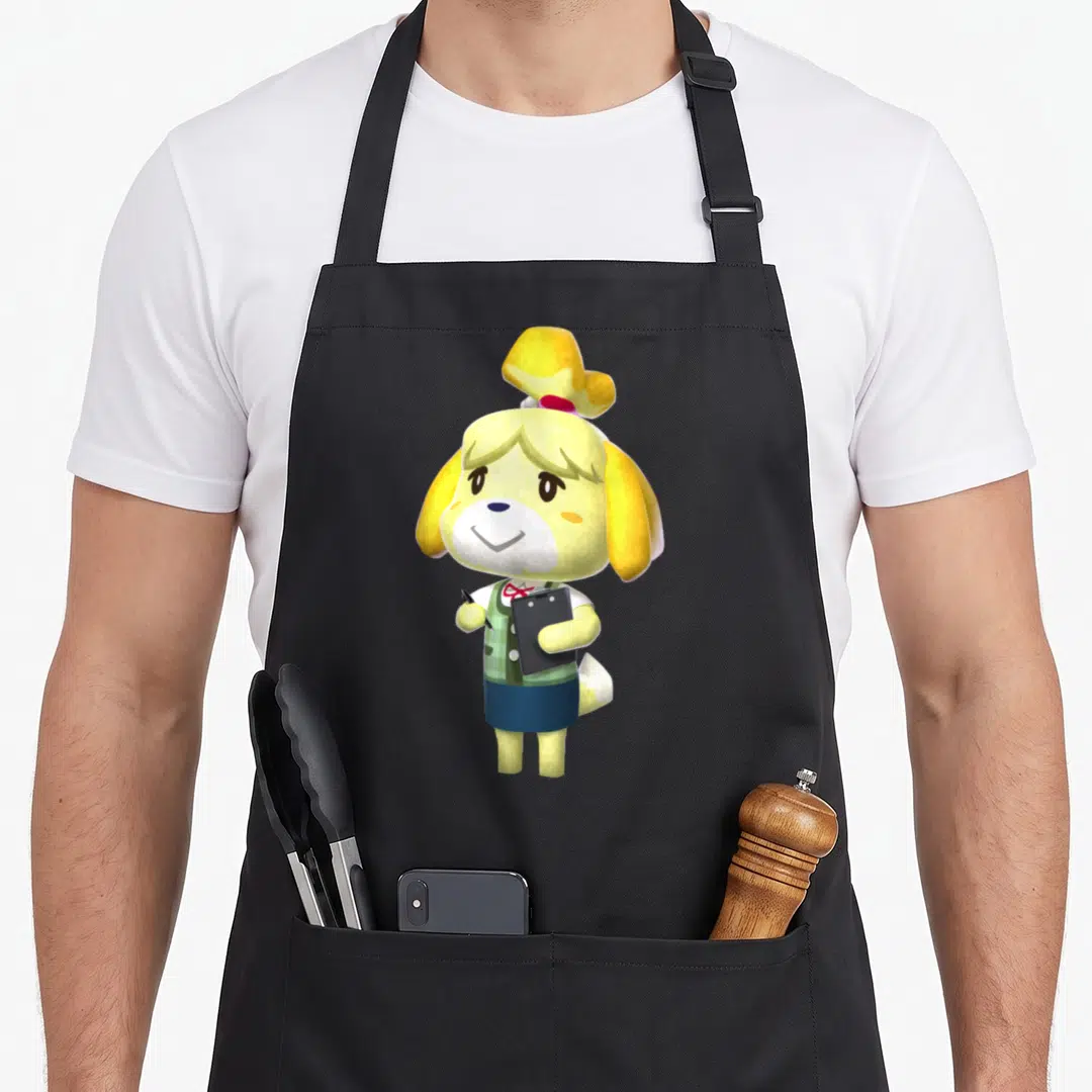 Isabelle animal apron - Cartoon yellow dog character holding a black clipboard and pen wearing a green vest — shown on a black cotton canvas apron against a white background