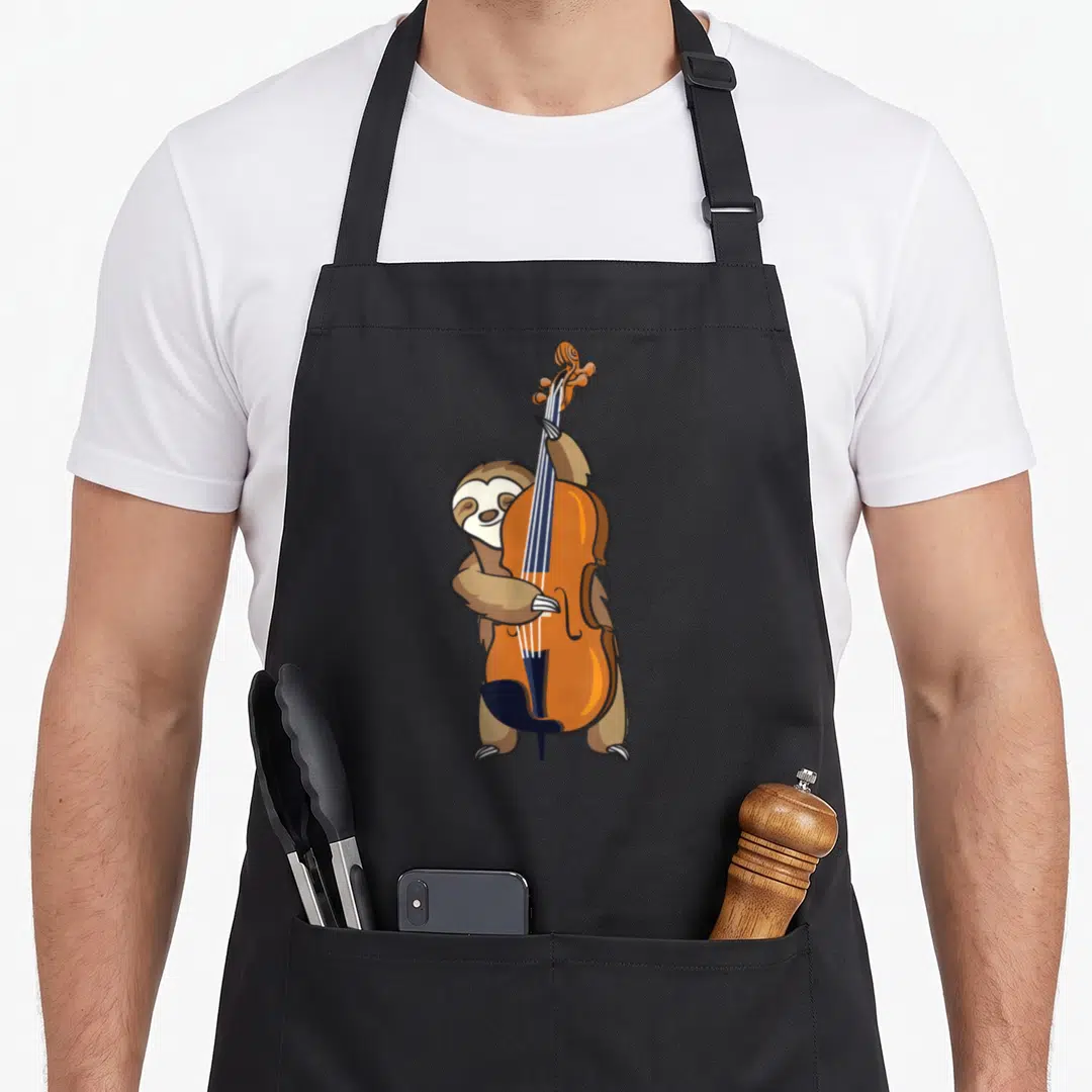 Jazz sloth apron - Cartoon brown sloth standing playing orange upright bass with dark blue strings — shown on a black cotton canvas apron against a white background