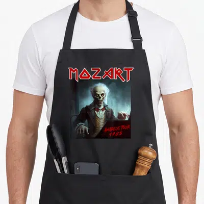 Mozart heavy apron - Skeleton Mozart in 18th-century clothes playing piano with red band logo text — shown on a black cotton canvas apron against a white background
