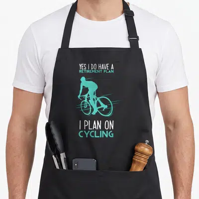 Retirement bicycle apron - Teal cyclist silhouette between white and teal text reading Yes I Do Have A Retirement Plan — shown on a black cotton canvas apron against a white background