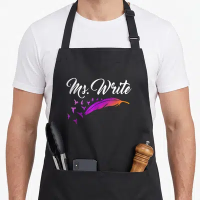 Author editor apron - Ms. Write text over purple-orange feather with small birds flying left — shown on a black cotton canvas apron against a white background