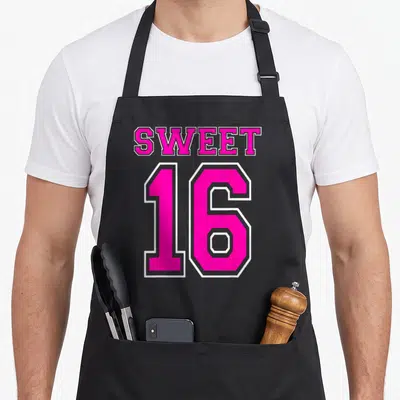 Sweet hot pink apron - SWEET 16 text in pink athletic font with white outline on black background — shown on a black cotton canvas apron against a white background