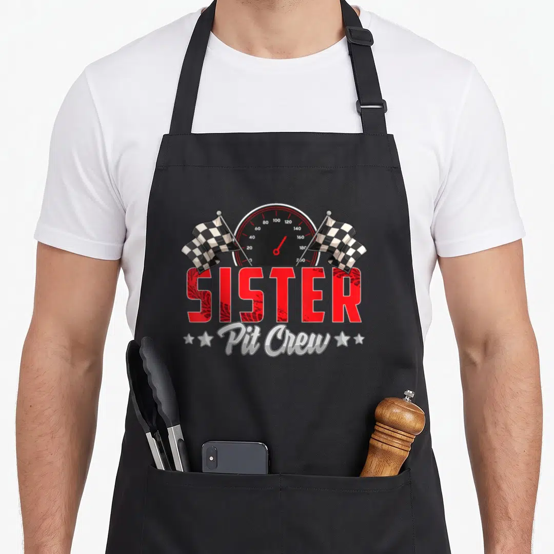 Sister car apron - Speedometer with checkered flags and SISTER in red tire tread font above Pit Crew in silver script — shown on a black cotton canvas apron against a white background