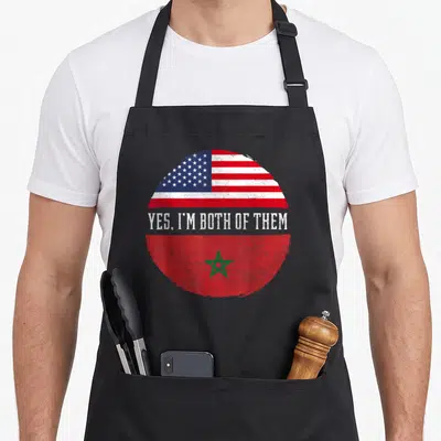 Morocco heritage american flag apron - Circular split design showing US and Morocco flags with Yes I'm Both Of Them — shown on a black cotton canvas apron against a white background