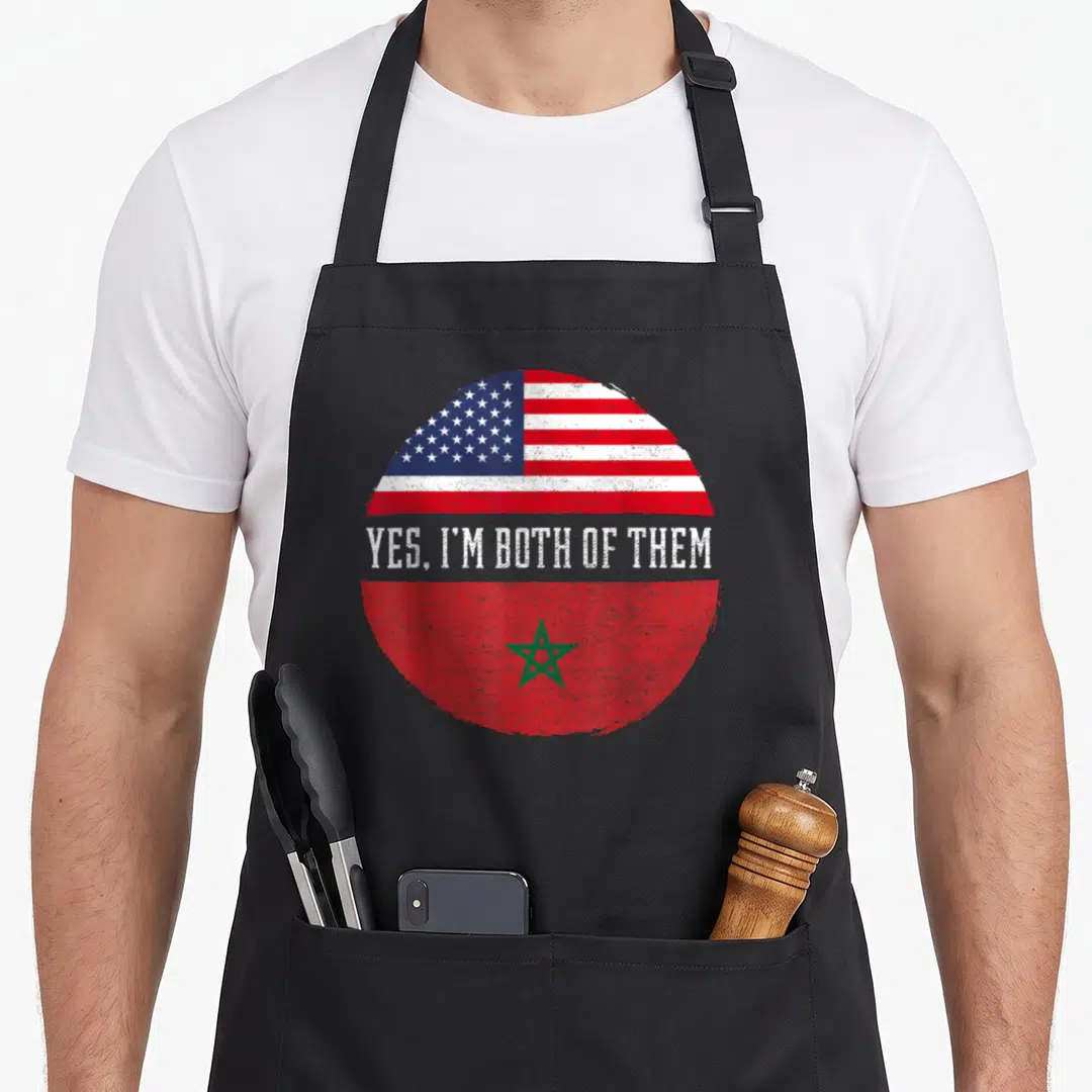 Morocco heritage american flag apron - Circular split design showing US and Morocco flags with Yes I'm Both Of Them — shown on a black cotton canvas apron against a white background