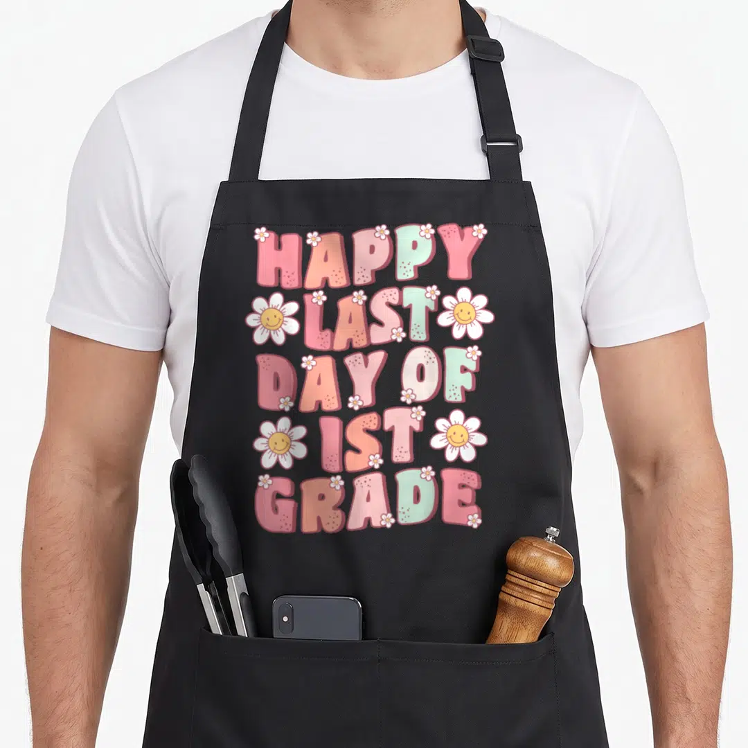 1st grade groovy teacher apron - Stacked text Happy Last Day of 1st Grade with pink peach blue white letters — shown on a black cotton canvas apron against a white background