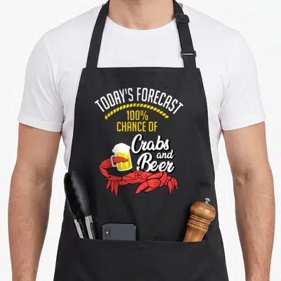 Beer crab apron - Cartoon red crab holding beer mug below white and yellow forecast text — shown on a black cotton canvas apron against a white background