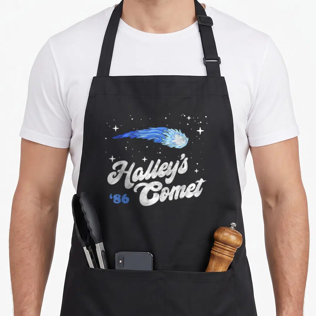 Halley 80s apron - Blue and white comet graphic with Halley's Comet '86 text on black background — shown on a black cotton canvas apron against a white background