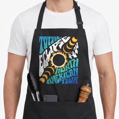 Total astronomer apron - Retro solar eclipse graphic with warped text Total Eclipse 4-8-24 North American Tour and six — shown on a black cotton canvas apron against a white background