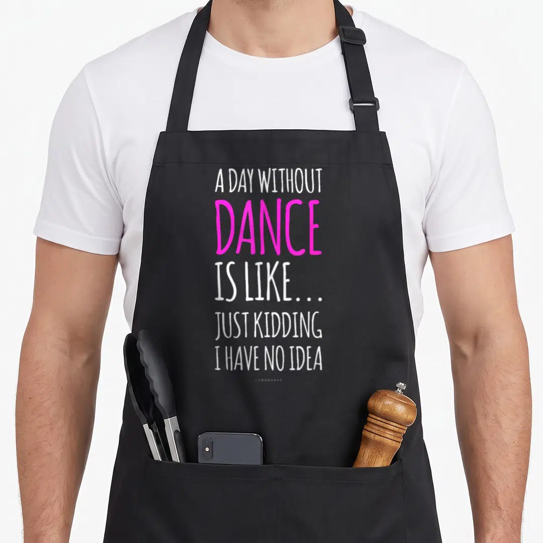 Funny dance apron - White and pink stacked text reading A Day Without Dance Is Like Just Kidding I Have No Idea — shown on a black cotton canvas apron against a white background