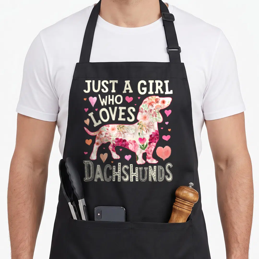 Dog dachshund apron - Floral dachshund silhouette with hearts and text Just A Girl Who Loves Dachshunds — shown on a black cotton canvas apron against a white background