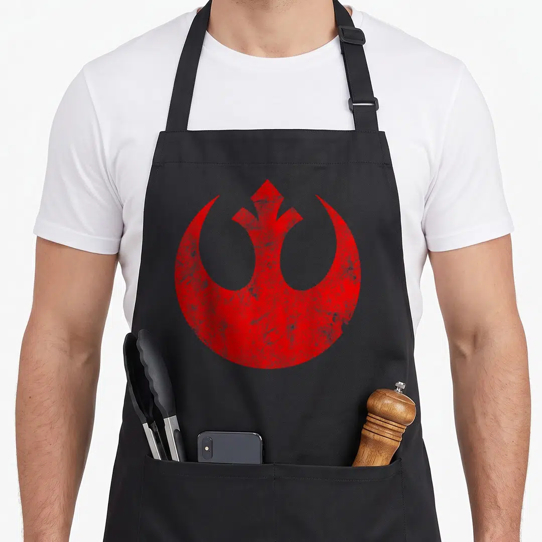 Rebel distressed apron - Red Rebel Alliance symbol with distressed texture and two front pockets — shown on a black cotton canvas apron against a white background