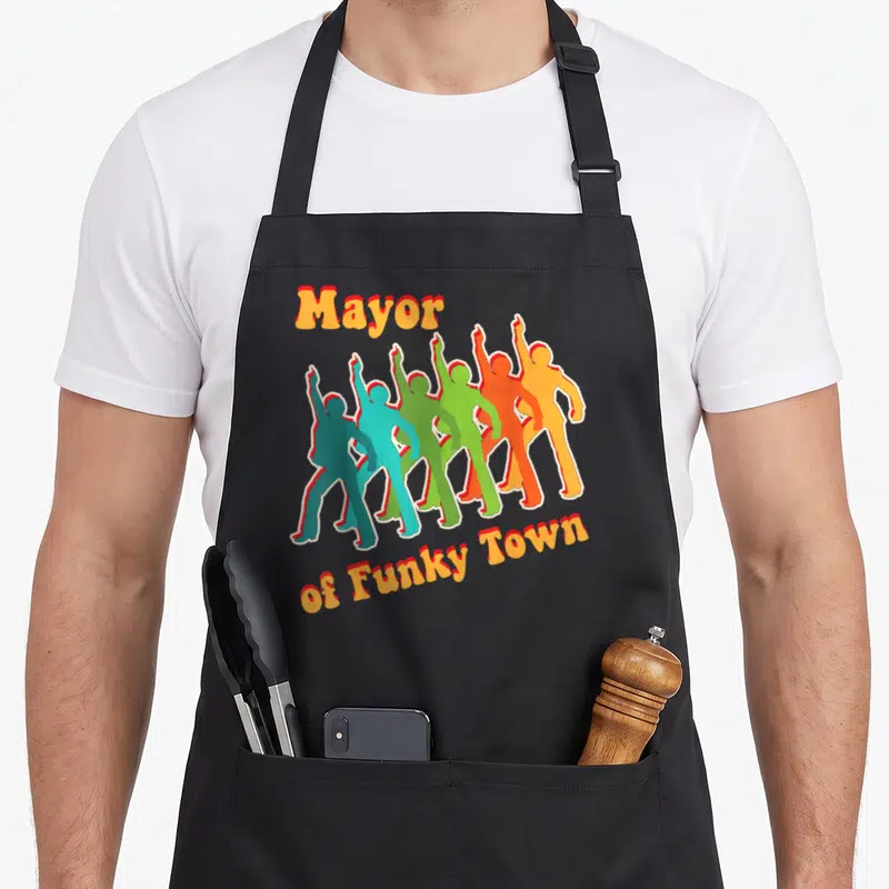 Groovy funky apron - Six colorful dancing silhouettes with Mayor of Funky Town text in retro style — shown on a black cotton canvas apron against a white background