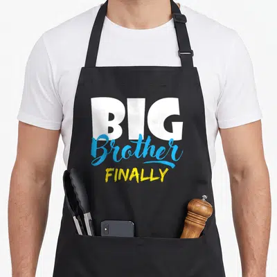 Finally brother apron - BIG Brother FINALLY text in white blue and yellow stacked typography — shown on a black cotton canvas apron against a white background