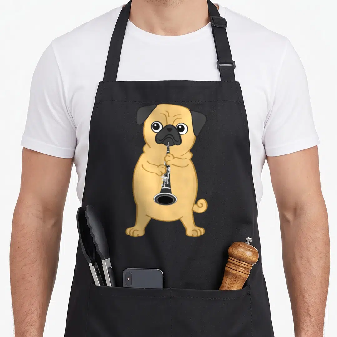 Clarinet dog apron - Cartoon tan pug standing and holding a black clarinet with silver keys — shown on a black cotton canvas apron against a white background